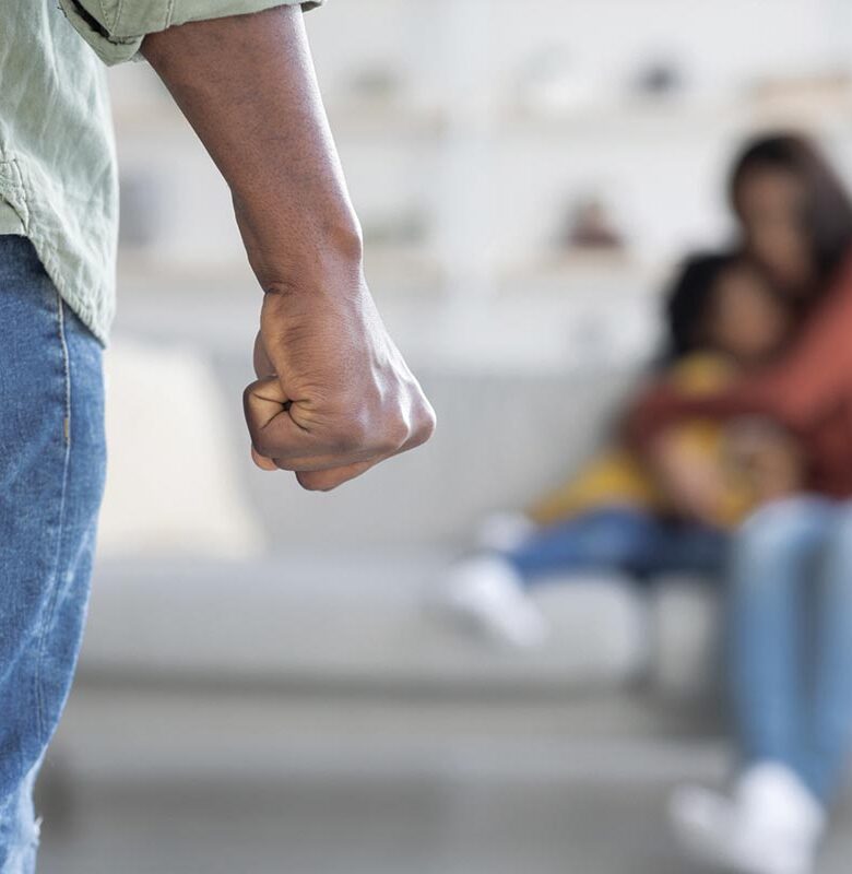 Domestic Violence. African American Man Threatening Wife And Daughter With His Fist