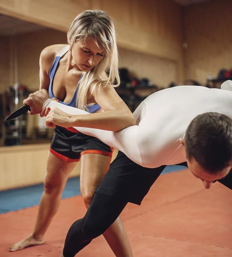 Woman makes elbow kick, self defense workout