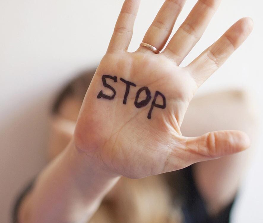 Woman shows palm with the inscription on the palm "Stop"