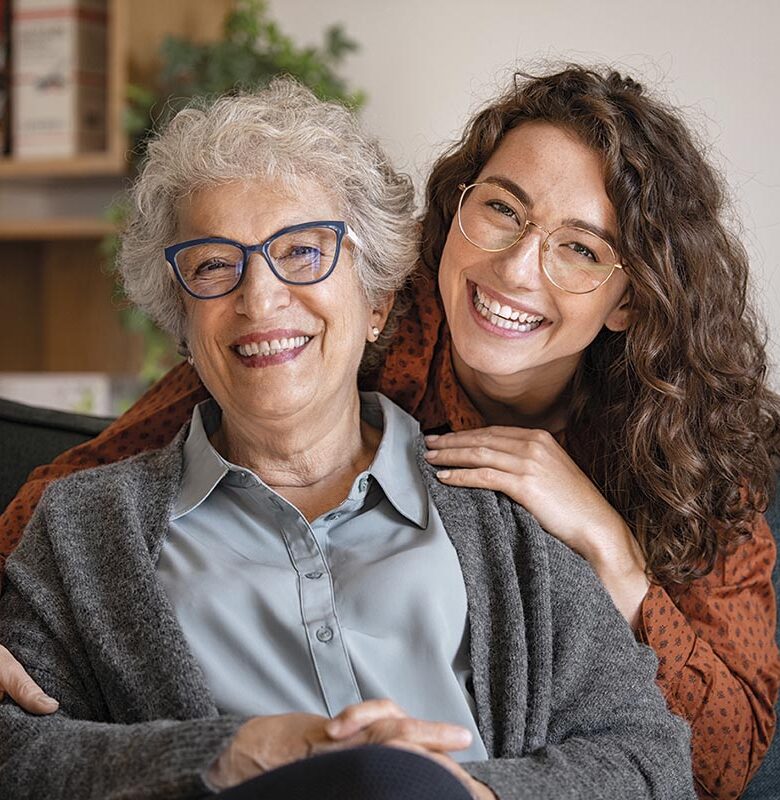 Happy grandmother with smiling granddaughter at home