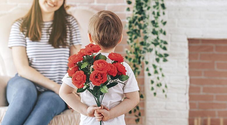 Boy holding a bouquet of flowers behind his back