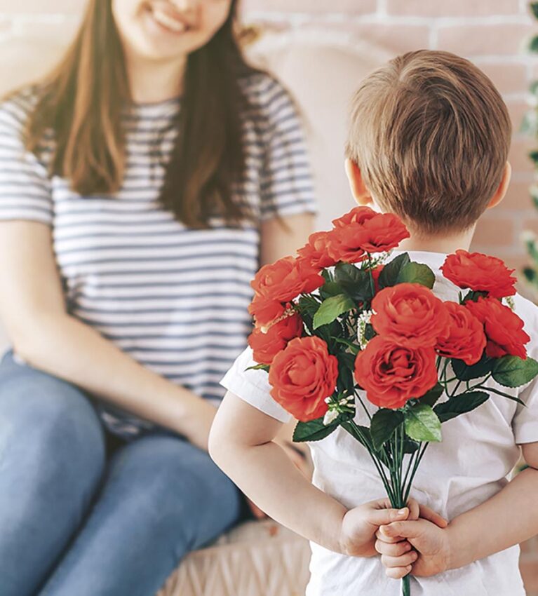 Boy holding a bouquet of flowers behind his back