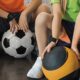 Cropped view of children sitting on step platforms with balls in