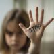 The child makes a stop gesture with his hand. Stop domestic and child abuse.