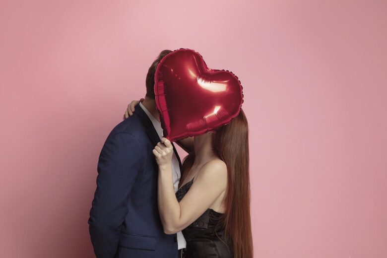 Valentine's day celebration, happy caucasian couple isolated on coral background