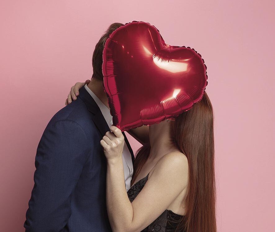 Valentine's day celebration, happy caucasian couple isolated on coral background