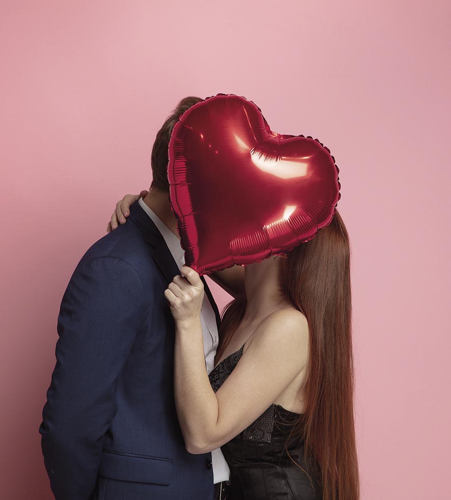 Valentine's day celebration, happy caucasian couple isolated on coral background